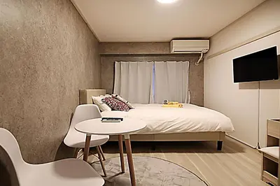 a bedroom with a bed and a table and a tv at HEISIEI HOUSE Shin-Ōkubo FREE WIFI in Tokyo