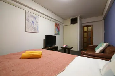 a bedroom with a bed with a yellow towel on it at HEISIEI HOUSE Shin-Ōkubo FREE WIFI in Tokyo
