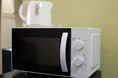 a microwave with a coffee pot on top of it at YOSHINO HOUSE!! Central Shinjuku Okubo Stay - Comfortable & Convenient in Tokyo