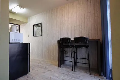 a bar with three black stools in a room at YOSHINO HOUSE!! Central Shinjuku Okubo Stay - Comfortable & Convenient in Tokyo
