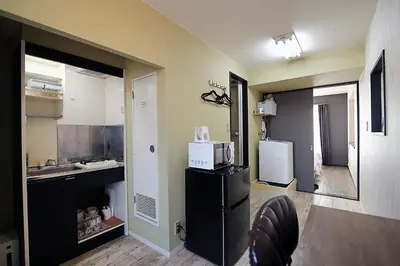 a kitchen with a black refrigerator and a microwave at YOSHINO HOUSE!! Central Shinjuku Okubo Stay - Comfortable & Convenient in Tokyo