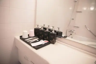 a bathroom with a counter with cosmetics and a mirror at Ueno Colon Hotel in Tokyo