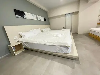 a bedroom with a large bed with white sheets at Ueno Colon Hotel in Tokyo
