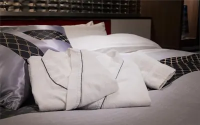 a pile of towels on a bed with pillows at HOTEL KABUKI in Tokyo