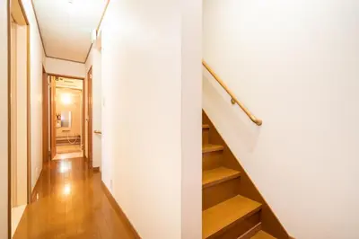 a hallway with stairs and a white wall at Hanamikaku\u522b\u5885110\u5e73\u65b9 4LDK,\u4e1c\u4eac\u7ad913\u5206 \u65b0\u5bbf25\u5206 \u79cb\u8449\u539f14\u5206 \u9280\u5ea730\u5206 \u6e0b\u8c3736 in Tokyo