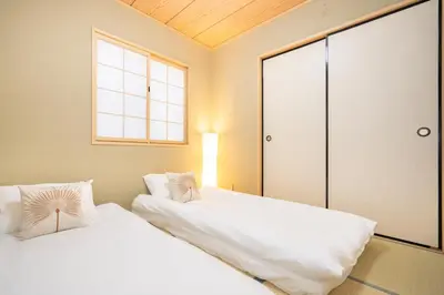 two white beds in a room with a window at Hanamikaku\u522b\u5885110\u5e73\u65b9 4LDK,\u4e1c\u4eac\u7ad913\u5206 \u65b0\u5bbf25\u5206 \u79cb\u8449\u539f14\u5206 \u9280\u5ea730\u5206 \u6e0b\u8c3736 in Tokyo