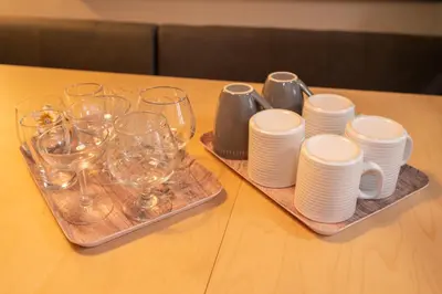 a table with plates and cups and wine glasses at Hanamikaku\u522b\u5885110\u5e73\u65b9 4LDK,\u4e1c\u4eac\u7ad913\u5206 \u65b0\u5bbf25\u5206 \u79cb\u8449\u539f14\u5206 \u9280\u5ea730\u5206 \u6e0b\u8c3736 in Tokyo
