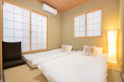two beds in a room with two windows at Hanamikaku\u522b\u5885110\u5e73\u65b9 4LDK,\u4e1c\u4eac\u7ad913\u5206 \u65b0\u5bbf25\u5206 \u79cb\u8449\u539f14\u5206 \u9280\u5ea730\u5206 \u6e0b\u8c3736 in Tokyo