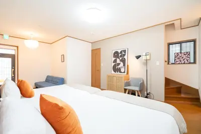 a bedroom with a large white bed and a blue chair at Hanamikaku\u522b\u5885110\u5e73\u65b9 4LDK,\u4e1c\u4eac\u7ad913\u5206 \u65b0\u5bbf25\u5206 \u79cb\u8449\u539f14\u5206 \u9280\u5ea730\u5206 \u6e0b\u8c3736 in Tokyo