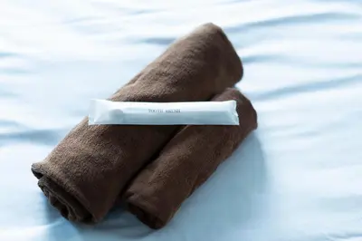 a pair of brown mittens sitting on a bed at SATELLITE HOTEL Roppongi \u30b5\u30c6\u30e9\u30a4\u30c8\u30db\u30c6\u30eb\u516d\u672c\u6728 in Tokyo