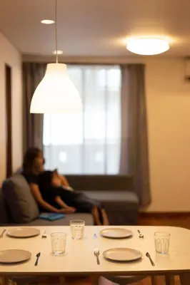 a couple sitting on a couch in a living room with a table at SATELLITE HOTEL Roppongi \u30b5\u30c6\u30e9\u30a4\u30c8\u30db\u30c6\u30eb\u516d\u672c\u6728 in Tokyo