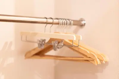 a metal rack with wooden hangers on a wall at SATELLITE HOTEL Roppongi \u30b5\u30c6\u30e9\u30a4\u30c8\u30db\u30c6\u30eb\u516d\u672c\u6728 in Tokyo