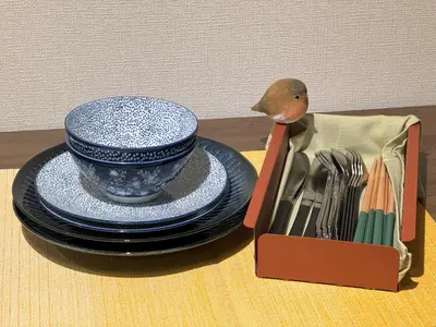 a box with a blue and white cup and plates and forks at nestay apartment tokyo shinjuku in Tokyo