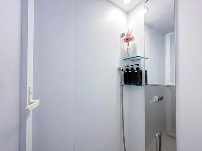a white bathroom with a refrigerator in a room at nestay apartment tokyo shinjuku in Tokyo