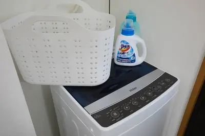 a bottle of milk and a basket on top of a washing machine at Japanese Tradition Hotel Evergreen in Tokyo