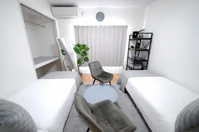 a room with two beds and a chair at Close to Shinjuku!Twin beds,Projector,Appliances! in Tokyo