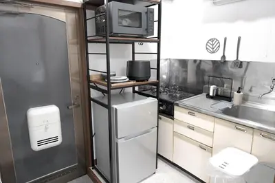 a kitchen with a refrigerator and a microwave at Close to Shinjuku!Twin beds,Projector,Appliances! in Tokyo