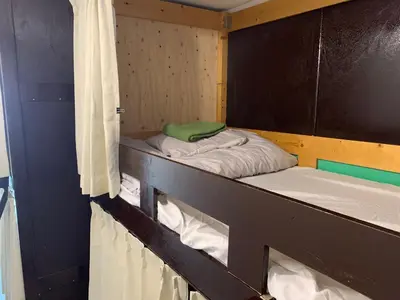 two bunk beds in a room with a curtain at Hostel Lodging Tokyo Ueno in Tokyo
