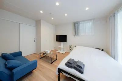 a bedroom with a bed and a blue couch at Higashi Komagata House by Tranova in Tokyo