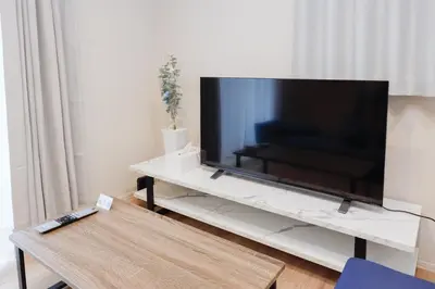 a large flat screen tv sitting on a white entertainment center at Higashi Komagata House by Tranova in Tokyo
