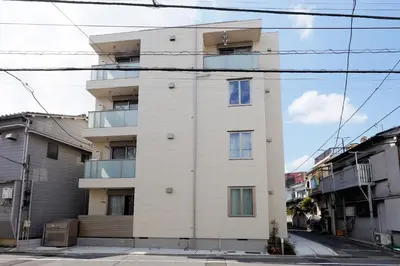 a tall white building on the side of a street at Higashi Komagata House by Tranova in Tokyo