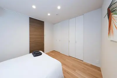 a bedroom with white cabinets and a bed at Higashi Komagata House by Tranova in Tokyo