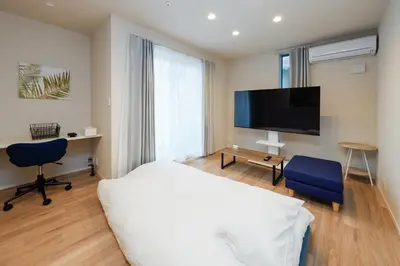 a bedroom with a bed and a flat screen tv at Higashi Komagata House by Tranova in Tokyo