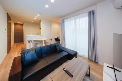 a living room with a black couch and a table at Higashi Komagata House by Tranova in Tokyo
