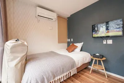a bedroom with a bed and a tv on the wall at Tokyo IKOI HOTEL\u30fc\u7dba\u9e97\u306a\u30db\u30c6\u30eb in Tokyo