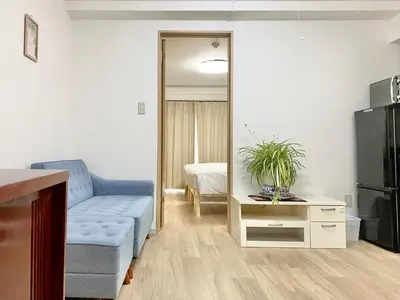 a living room with a blue couch and a television at Ueno\u6b63\u548c\u30d3\u30eb in Tokyo