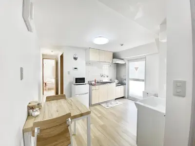 a kitchen with white cabinets and a wooden table at Ueno\u6b63\u548c\u30d3\u30eb in Tokyo