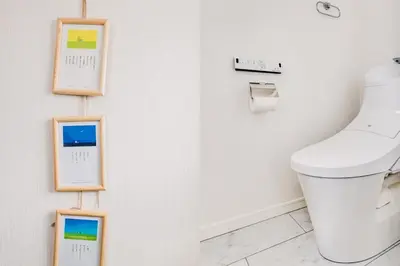 a bathroom with a toilet and pictures on the wall at self-check in-House,Ueno sky tree area, free wifi 3LDK in Tokyo