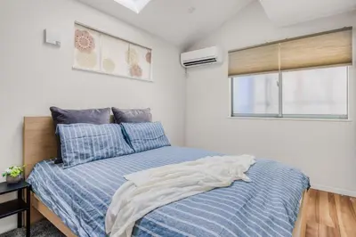 a bedroom with a bed with a blue comforter and a window at self-check in-House,Ueno sky tree area, free wifi 3LDK in Tokyo