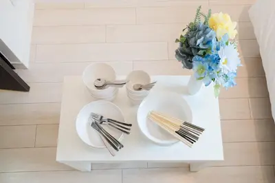 a table with plates and forks and a vase of flowers at Square Shibuya in Tokyo