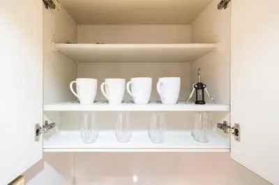 a cupboard with three white cups on a shelf at Square Shibuya in Tokyo