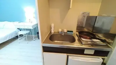 a kitchen with a sink and a bed in a room at OkuboZYZ SJ0244 in Tokyo