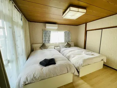 a small bedroom with two beds with white sheets at Nishi-Shinjuku 3LDK SJ0243 in Tokyo