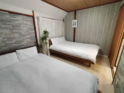 a small room with two beds and a window at Nishi-Shinjuku 3LDK SJ0243 in Tokyo