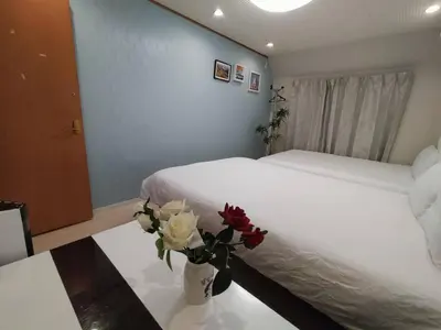 a bedroom with a bed and flowers on a table at Nishi-Shinjuku 3LDK SJ0243 in Tokyo