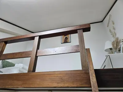 a wooden bed frame in a bedroom at Shibuya SG House Free Wifi in Tokyo