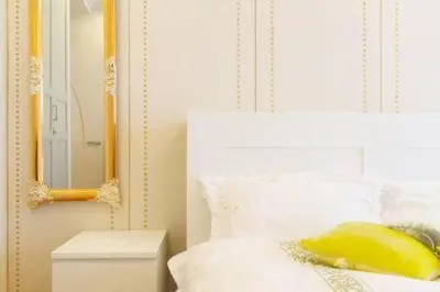a bedroom with a white bed with a yellow pillow and a mirror at Reimi Mondo9 in Tokyo