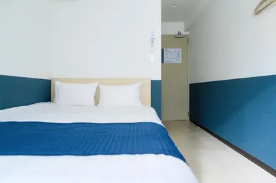 a bedroom with a bed with blue and white at Ueno Woo Hotel in Tokyo