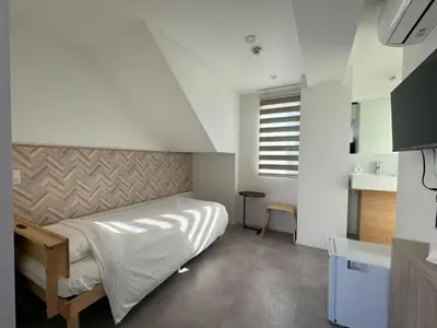 a small bedroom with a bed and a sink at Hotel Apreton in Tokyo