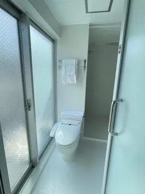 a bathroom with a toilet and a glass shower at Hotel Apreton in Tokyo