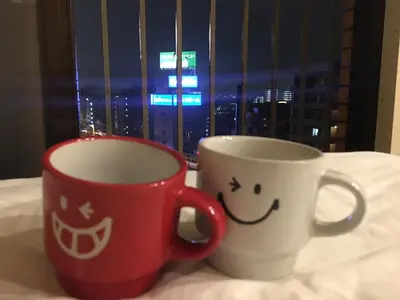 two coffee cups sitting on a table in front of a window at 10 minutes direct to Shibuya Crossing! Heart of Tokyo! Mishuku in Tokyo