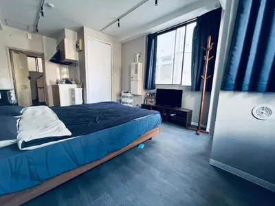a bedroom with a bed with blue sheets and a window at \u4e1c\u4eac\u4e2d\u5fc3\u5168\u65b0\u88c5\u4fee\u5bbd\u655e\u660e\u4eae\u7684\u516c\u5bd3 3\u5206\u949f\u6b65\u884c\u8def\u7a0b\u5230\u95e8\u524d\u4ef2\u753a\u7ad9 \u4e24\u6761\u5730\u94c1\u7ebf\u76f4\u8fbe\u4e1c\u4eac\u4e0a\u91ce\u65b0\u5bbf201 in Tokyo