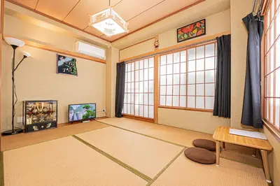 a living room with a large window and a table at 302\u4e1c\u4eac\u4e2d\u5fc3\u5168\u65b0\u88c5\u4fee\u5bbd\u655e\u660e\u4eae\u7684\u516c\u5bd3 3\u5206\u949f\u6b65\u884c\u8def\u7a0b\u5230\u95e8\u524d\u4ef2\u753a\u7ad9 \u4e24\u6761\u5730\u94c1\u7ebf\u76f4\u8fbe\u4e1c\u4eac\u4e0a\u91ce\u65b0\u5bbf in Tokyo