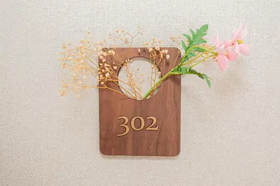 a wooden plaque with a number and flowers on a wall at 302\u4e1c\u4eac\u4e2d\u5fc3\u5168\u65b0\u88c5\u4fee\u5bbd\u655e\u660e\u4eae\u7684\u516c\u5bd3 3\u5206\u949f\u6b65\u884c\u8def\u7a0b\u5230\u95e8\u524d\u4ef2\u753a\u7ad9 \u4e24\u6761\u5730\u94c1\u7ebf\u76f4\u8fbe\u4e1c\u4eac\u4e0a\u91ce\u65b0\u5bbf in Tokyo