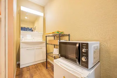 a microwave sitting on top of a counter in a kitchen at 302\u4e1c\u4eac\u4e2d\u5fc3\u5168\u65b0\u88c5\u4fee\u5bbd\u655e\u660e\u4eae\u7684\u516c\u5bd3 3\u5206\u949f\u6b65\u884c\u8def\u7a0b\u5230\u95e8\u524d\u4ef2\u753a\u7ad9 \u4e24\u6761\u5730\u94c1\u7ebf\u76f4\u8fbe\u4e1c\u4eac\u4e0a\u91ce\u65b0\u5bbf in Tokyo