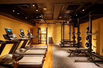 a gym with a row of treadmills and machines at Sauna & Cabin Thermae-yu Nishiazabu in Tokyo